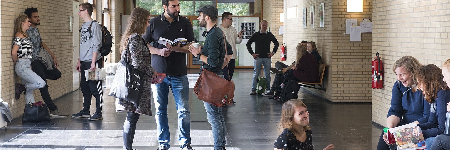 Das Bild zeigt Studierende, die sich im Flur des EHB-Bibliotheksgebäudes aufhalten im 