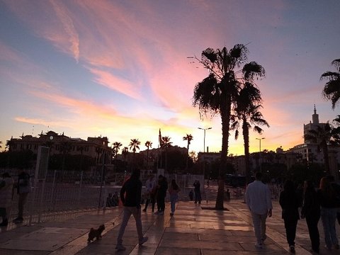 Das Bild zeigt einen Sonnenuntergang über einer Straße.